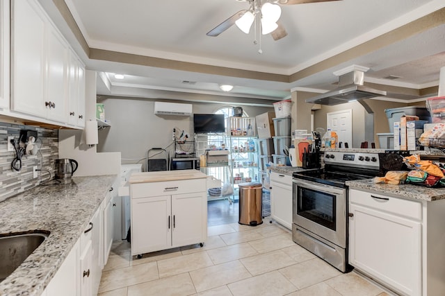 kitchen with stainless steel range with electric stovetop, white cabinetry, light tile patterned floors, and a tray ceiling