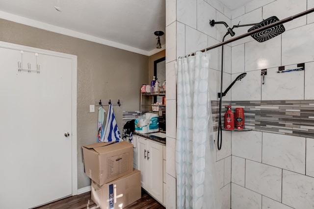 bathroom featuring hardwood / wood-style flooring, a shower with curtain, and ornamental molding