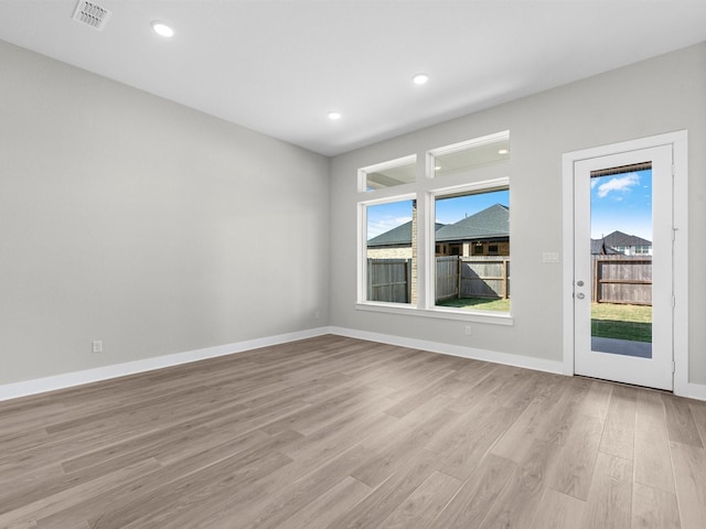 unfurnished room with light wood-type flooring and a healthy amount of sunlight