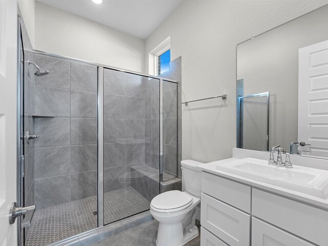 bathroom with toilet, a shower with door, and vanity