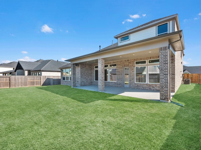 rear view of house with central air condition unit, a yard, and a patio