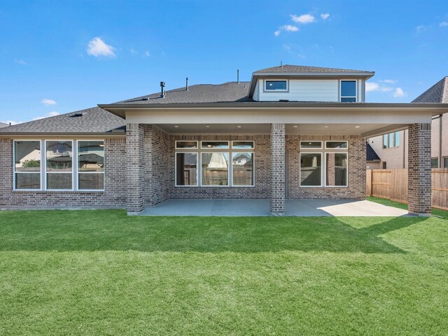 rear view of house featuring a patio and a yard