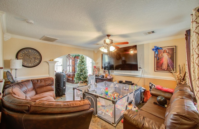 living room featuring ornate columns, crown molding, ceiling fan, and a textured ceiling