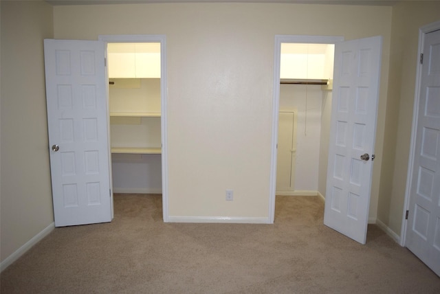 unfurnished bedroom featuring light carpet, a spacious closet, and a closet