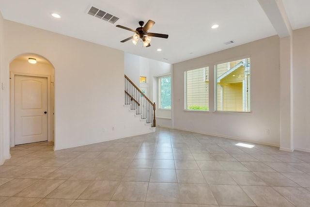 tiled spare room with ceiling fan