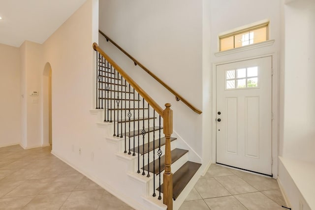 tiled foyer entrance featuring a towering ceiling