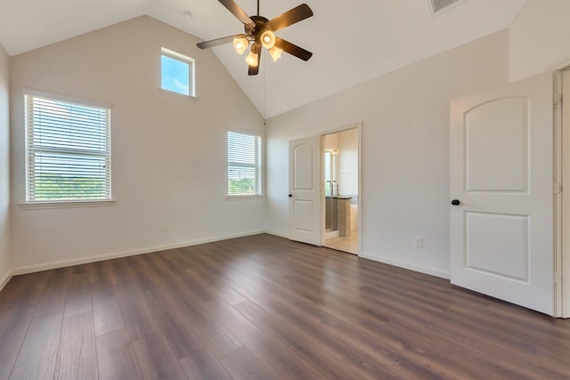 unfurnished bedroom with multiple windows, dark hardwood / wood-style flooring, connected bathroom, and ceiling fan