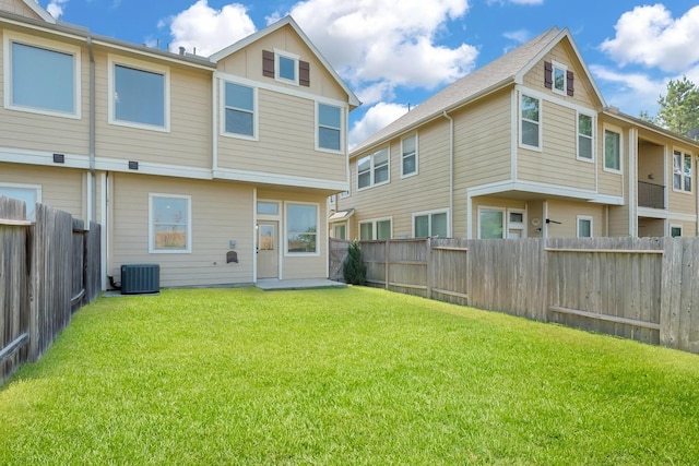 back of property with a lawn and cooling unit