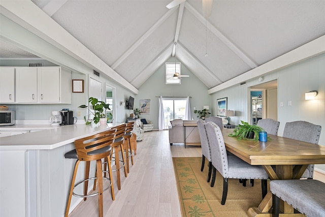 16904 Beachcomber Dr, Galveston, TX 77554 - dining space with light wood-style floors, beamed ceiling, a ceiling fan, and high vaulted ceiling