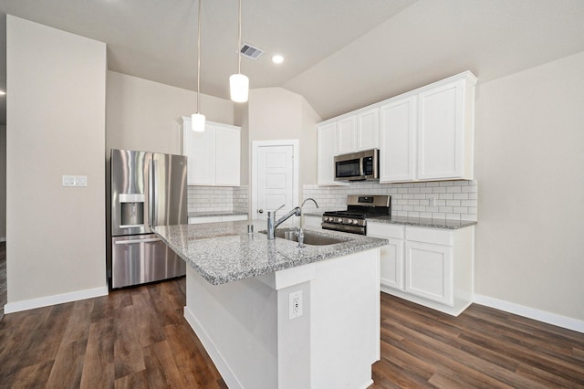 kitchen featuring white cabinetry, backsplash, vaulted ceiling, a kitchen island with sink, and appliances with stainless steel finishes