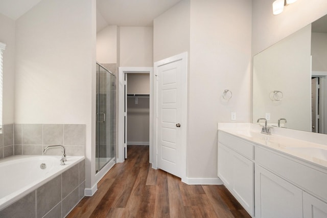 bathroom with vanity, wood-type flooring, independent shower and bath, and lofted ceiling