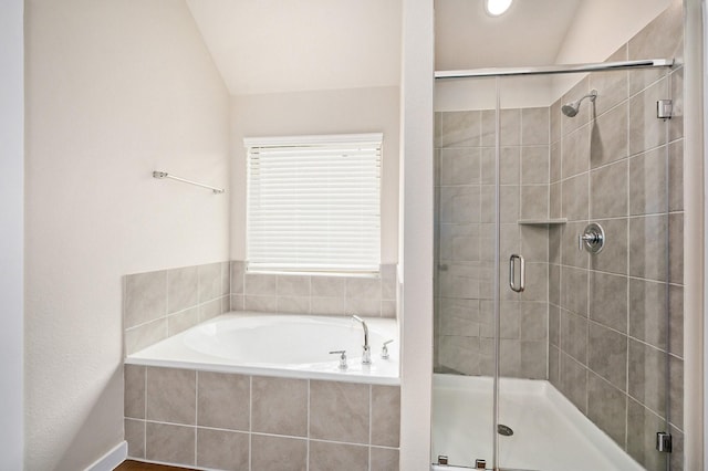 bathroom featuring shower with separate bathtub and vaulted ceiling