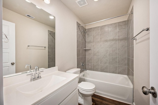 full bathroom with vanity, wood-type flooring, tiled shower / bath combo, and toilet