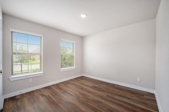 empty room with dark hardwood / wood-style flooring