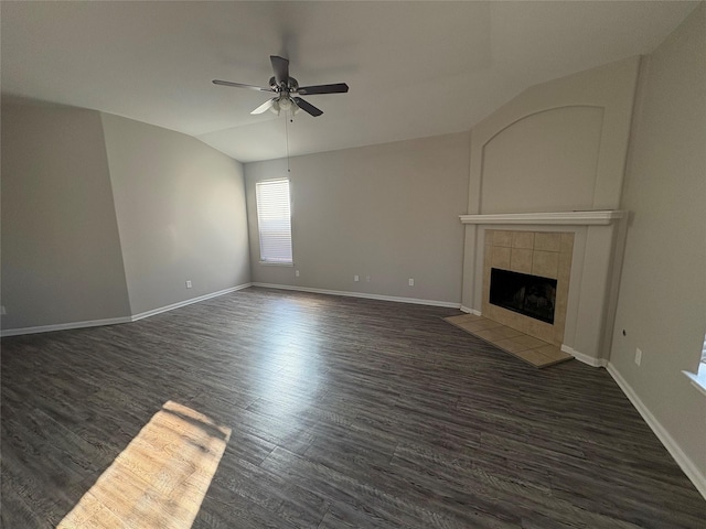 unfurnished living room with dark hardwood / wood-style floors, vaulted ceiling, ceiling fan, and a tiled fireplace