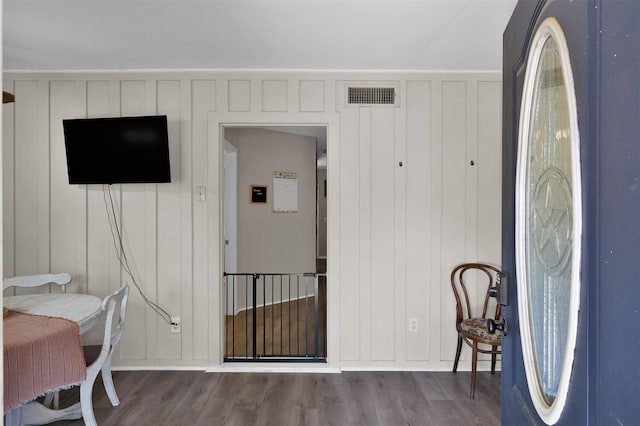 interior space with wooden walls and hardwood / wood-style floors