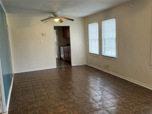 unfurnished living room featuring a textured ceiling, ceiling fan, and wood walls