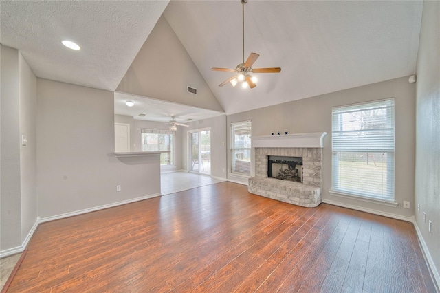 unfurnished living room featuring wood-type flooring, a healthy amount of sunlight, and a textured ceiling