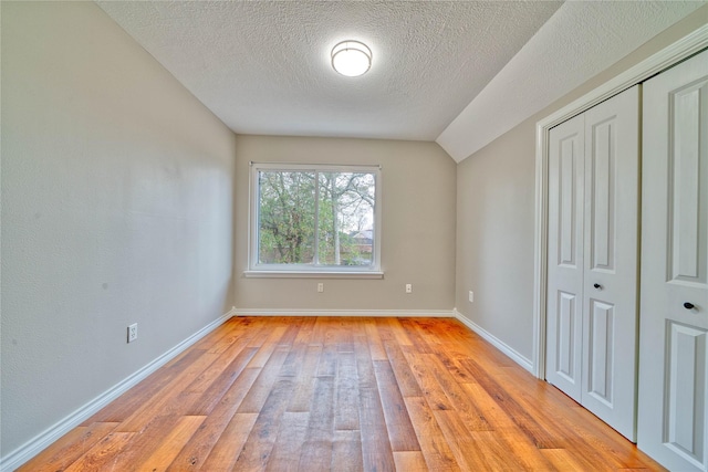 unfurnished bedroom with a closet, light hardwood / wood-style flooring, and a textured ceiling