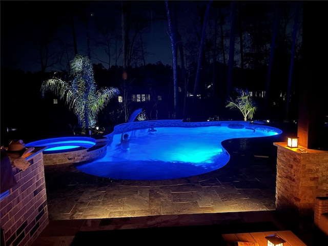 pool at twilight with an in ground hot tub