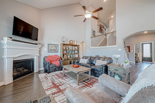 living room featuring ceiling fan, high vaulted ceiling, and dark hardwood / wood-style floors