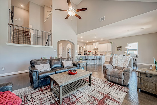 living room featuring wood-type flooring, high vaulted ceiling, and ceiling fan