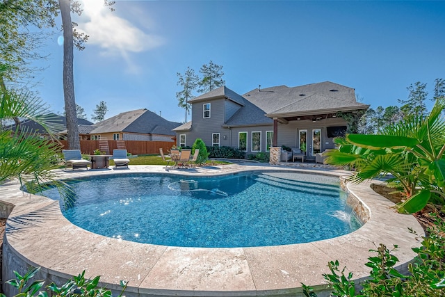 view of swimming pool with ceiling fan, french doors, pool water feature, and a patio