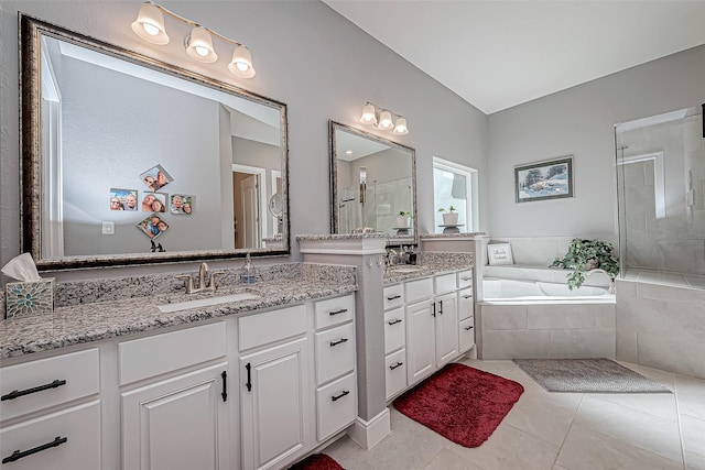 bathroom featuring plus walk in shower, vanity, and tile patterned floors