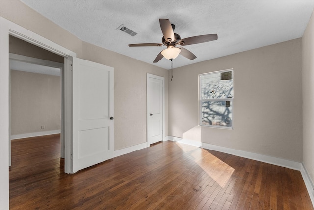 unfurnished bedroom featuring a textured ceiling, dark hardwood / wood-style flooring, and ceiling fan