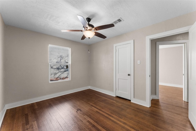 unfurnished bedroom with ceiling fan, dark hardwood / wood-style floors, and a textured ceiling