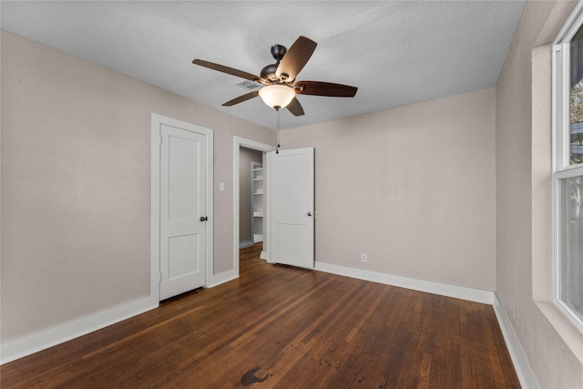 unfurnished bedroom featuring ceiling fan, dark hardwood / wood-style flooring, and a textured ceiling