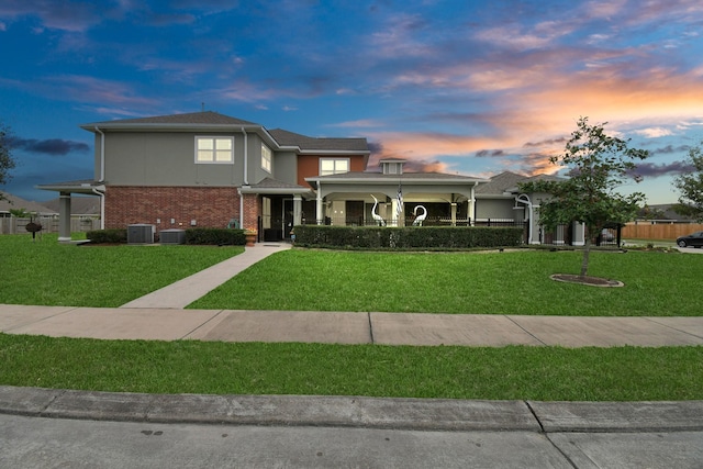 view of front facade featuring a lawn and central AC unit