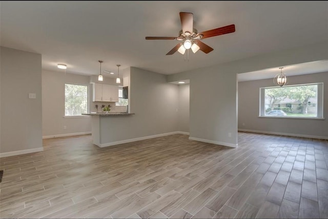 unfurnished living room featuring ceiling fan and light hardwood / wood-style flooring