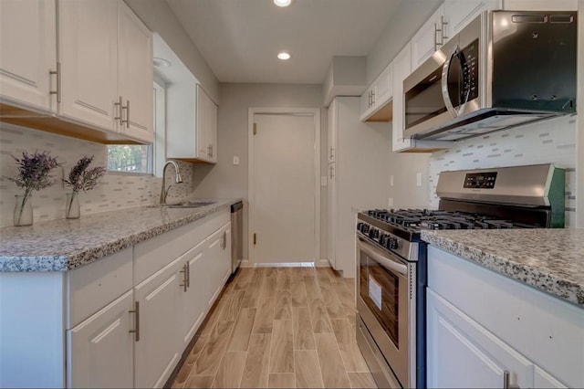 kitchen featuring white cabinetry, light hardwood / wood-style floors, and appliances with stainless steel finishes