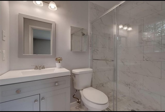 bathroom featuring vanity, toilet, and a shower with shower door