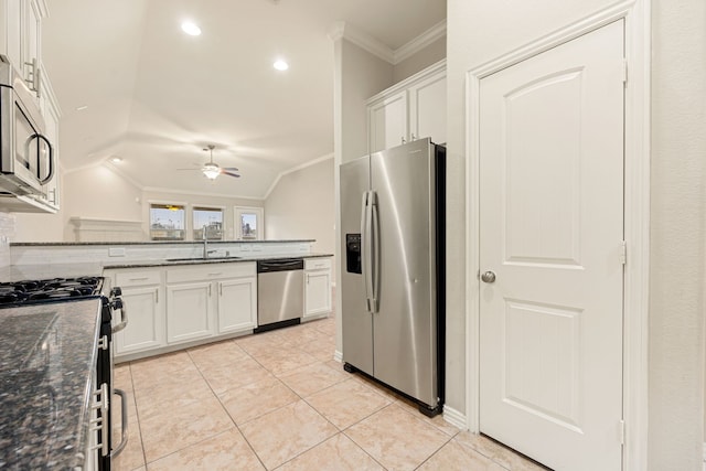 kitchen featuring ceiling fan, sink, dark stone counters, white cabinets, and appliances with stainless steel finishes