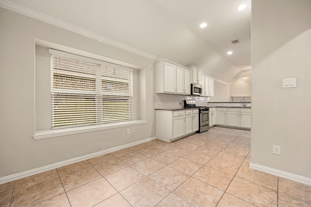 kitchen featuring backsplash, sink, vaulted ceiling, white cabinetry, and stainless steel appliances