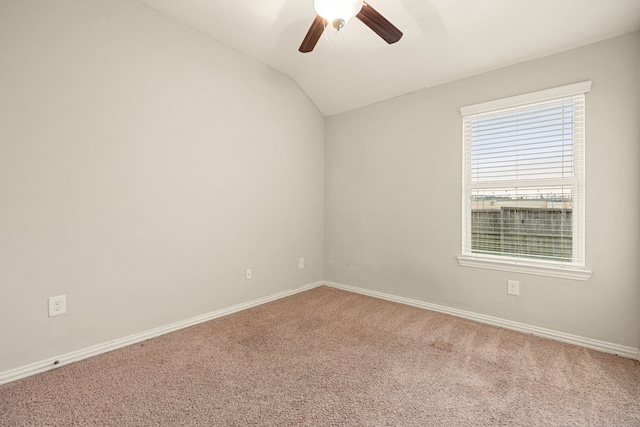 carpeted spare room with ceiling fan and vaulted ceiling