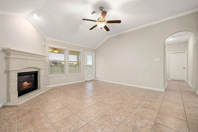 unfurnished living room with a tiled fireplace, crown molding, ceiling fan, and lofted ceiling