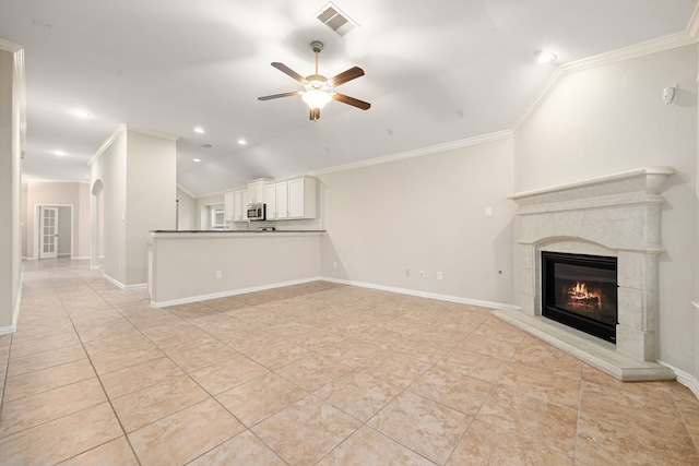 unfurnished living room with a tiled fireplace, ceiling fan, crown molding, and lofted ceiling