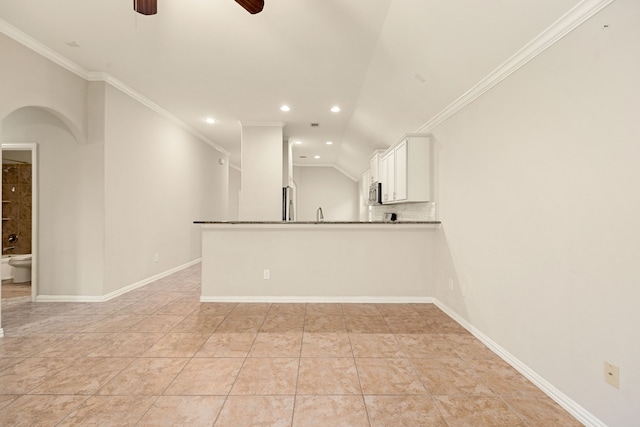 interior space featuring ceiling fan, ornamental molding, light tile patterned floors, and vaulted ceiling