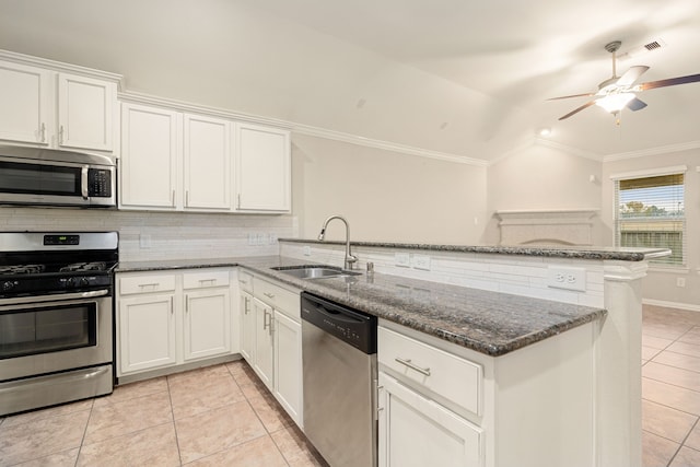 kitchen featuring kitchen peninsula, appliances with stainless steel finishes, sink, white cabinets, and lofted ceiling