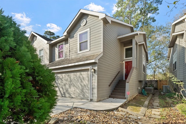 view of front of property featuring a garage and central air condition unit