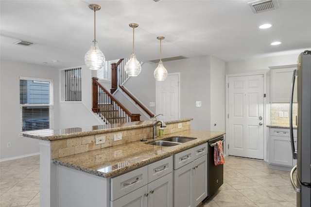 kitchen featuring pendant lighting, an island with sink, stainless steel appliances, and sink