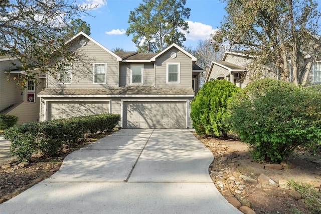 view of front of house with driveway, a shingled roof, and a garage