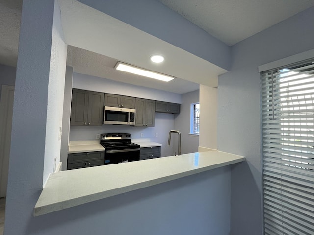 kitchen featuring kitchen peninsula, appliances with stainless steel finishes, and plenty of natural light