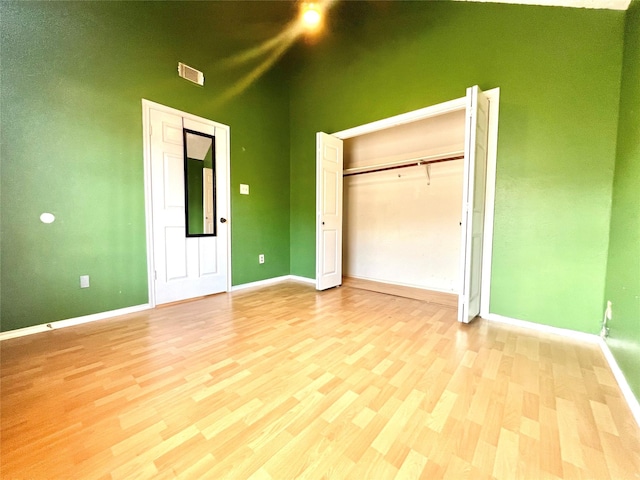 unfurnished bedroom featuring light hardwood / wood-style floors and a high ceiling