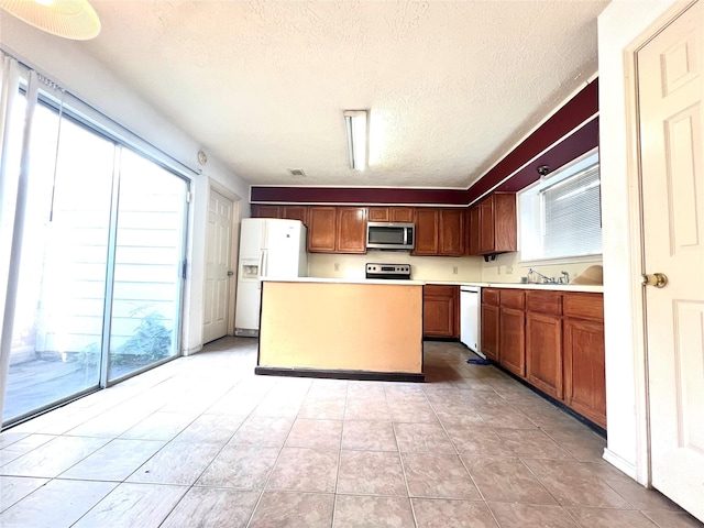 kitchen featuring dishwasher, light tile patterned floors, a kitchen island, and white fridge with ice dispenser