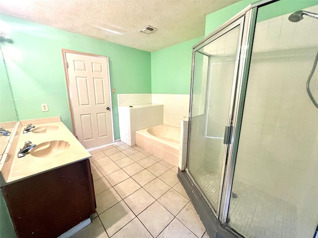 bathroom featuring tile patterned floors, vanity, shower with separate bathtub, and a textured ceiling