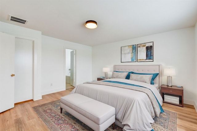 bedroom featuring light hardwood / wood-style floors and ensuite bath